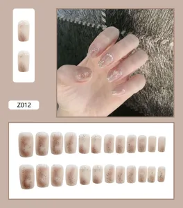 Vue détaillée de 24 faux ongles dégradés nude avec paillettes et perles élégantes