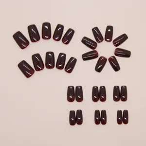 Complete set van 30 donker wijnrode glanzende kunstnagels gepresenteerd op een beige basis
