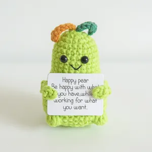 Close up detail view of handmade crochet green pear doll holding positive text sign decor.