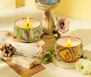Scented soy wax candles in decorative tin cans with boho floral patterns for gifts.