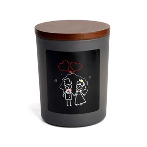 Gros plan d'un pot de bougie parfumée en verre givré gris avec couvercle en bois et autocollant.