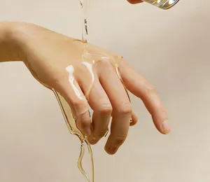 Close up of smooth liquid texture pouring gracefully on hand for skin care and fragrance details.