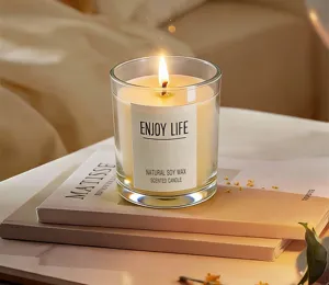 Close-up of a scented candle in a glass jar, burning with a warm glow on cozy room background.