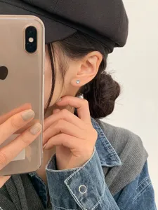 Dainty heart-shaped blue moonstone stud earring shown on an Asian female model.