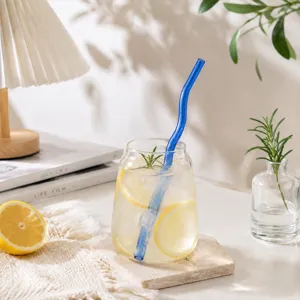 Transparent glass cup with blue wavy straw, creative drinkware for home kitchen table decor.