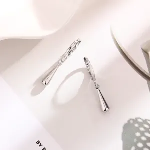 Nahaufnahme von minimalistischen silbernen Tropfenohrringen mit glatter Oberfläche.