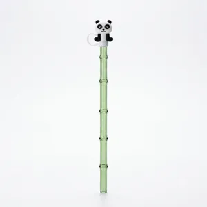 Detalle pajita de vidrio bambú verde con adorno de panda de silicona, resistente al calor.