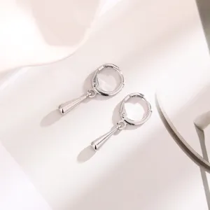 Nahaufnahme von minimalistischen silbernen Wassertropfen-Ohrringen mit poliertem Finish