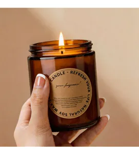 Amber glass scented candle detail view, natural soy wax, warm ambient lighting and cozy home decor.
