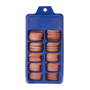 Vista detallada de uñas postizas largas de ballet en caja azul, color marrón nude