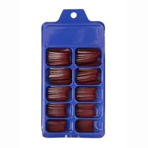 Detalle de uñas postizas largas de bailarina rojo oscuro en caja azul