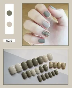 Set of 24 pieces grey-green and cream press-on nails with glitter accents shown on hand