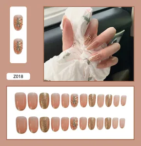 Vue détaillée de 24 faux ongles dégradés nude avec breloques papillon en strass