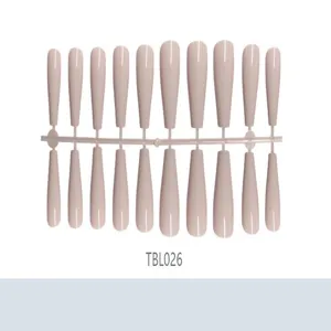Long ballerina false nail tips in nude color on a manufacturing strip packaging