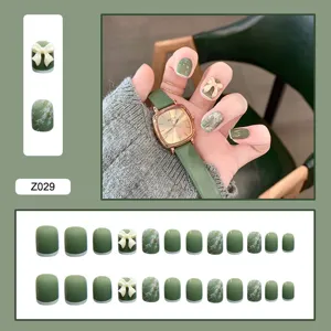 Vue détaillée de faux ongles verts avec texture marbrée et nœuds décoratifs, 24 pièces.
