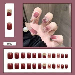Faux ongles bordeaux élégants avec nœuds papillons 3D, cœurs et décorations en perles.