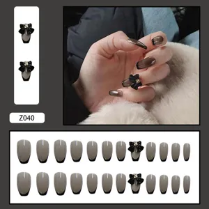Détail de 24 faux ongles dégradés gris avec décorations de nœuds noirs en 3D élégants