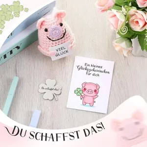 Detailed macro view of pink handmade crocheted pig doll gift set with German good luck cards