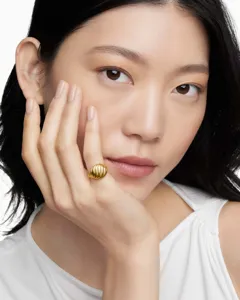Elegant 18K gold striped pleated ring shown on a model for a stylish lifestyle look