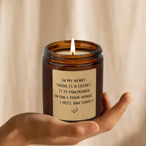 Amber glass jar scented candle in hand, soy wax aromatherapy for home decor and cozy gift.