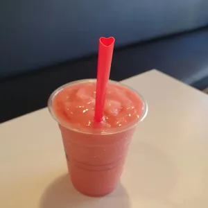 Rood hartvormig rietje detail getoond met roze smoothie, ideaal voor feestjes en lekkere desserts.