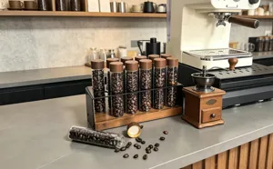 Détail ensemble tubes de stockage de grains de café en noyer, support en verre avec couvercle en bois.