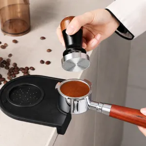 Close-up of stainless steel coffee distributor with wooden handle and threaded base for espresso.