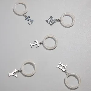 Elegante weiße Harzringe mit hängenden silbernen Metallbuchstabenanhängern für Damen
