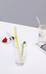 Colorful glass straw detail shot, transparent curved drinking straw set lifestyle display.