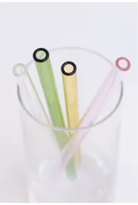 Detail view of colorful glass straws in a clear glass cup, showing pastel tones and neat design.