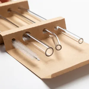 Transparent glass straw set with cleaning brush in kraft paper box, eco-friendly drinkware.