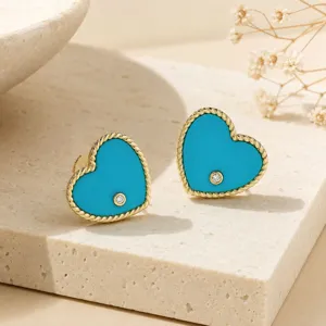 Detailed view of turquoise enamel heart stud earrings with 18k gold plated twisted edges