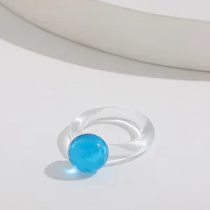 Detaillierte Nahaufnahme eines blauen transparenten Harzrings im geometrischen Y2K-Design.