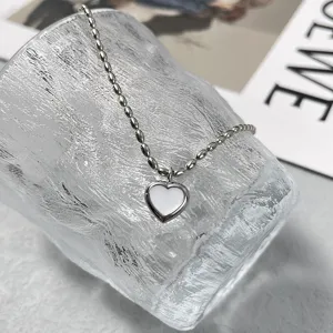 Detaillierte Nahaufnahme einer minimalistischen silbernen Herzkette auf einem Glas-Eiswürfel