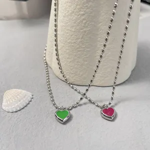 Detail der silbernen Kugelkettchen mit grünem und rosa emailliertem Herzanhänger