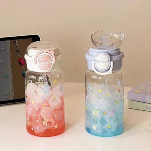Close-up of cute gradient plastic water bottles with star patterns and straws