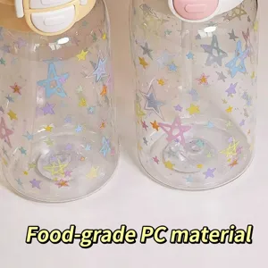 Close-up of two cute transparent water bottles with colorful star patterns and straws.