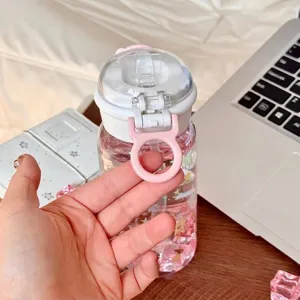 Detailansicht einer Trinkflasche aus Kunststoff mit rosa Trageschlaufe und Sternenmuster.