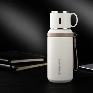 Bouteille thermos isolante sous vide en acier inoxydable avec couvercle tasse et sangle portable.