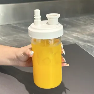 Detail view of a portable clear plastic boba straw water cup with white dual-port lid