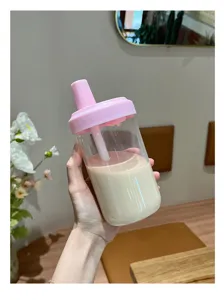 Vue détaillée d'un gobelet en plastique à paille rose rempli de thé au lait