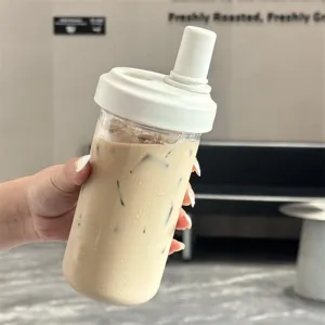 Detail view of a minimalist large capacity boba straw cup filled with iced milk tea