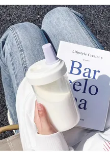 Minimalist large capacity portable plastic straw cup for cold brew held in a lifestyle setting