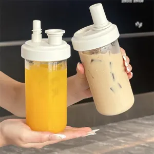 Detail showing two portable straw cups with different lids for juice and iced coffee