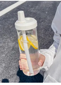 Close-up detail of a minimalist clear plastic water bottle with white straw and lemon slices