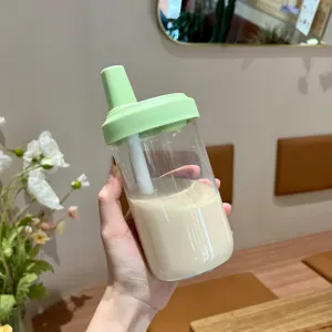 Gros plan d'un gobelet minimaliste vert clair avec paille rempli de thé au lait onctueux