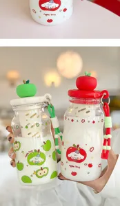 Dettaglio bottiglia d'acqua in vetro con coperchio a mela e colino da tè portatile