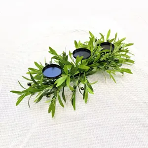 Macro detail of artificial olive branch candle holder with three black iron candle trays