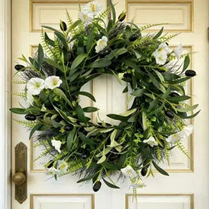 Realistic olive leaf wreath with white flowers hanging on a classic white front door.