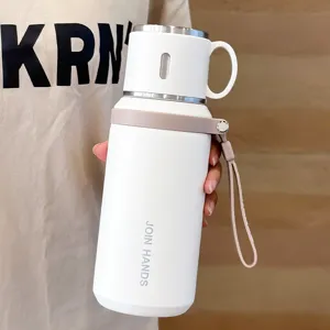 Botella de agua térmica portátil de acero inoxidable con tapa y correa para uso diario.